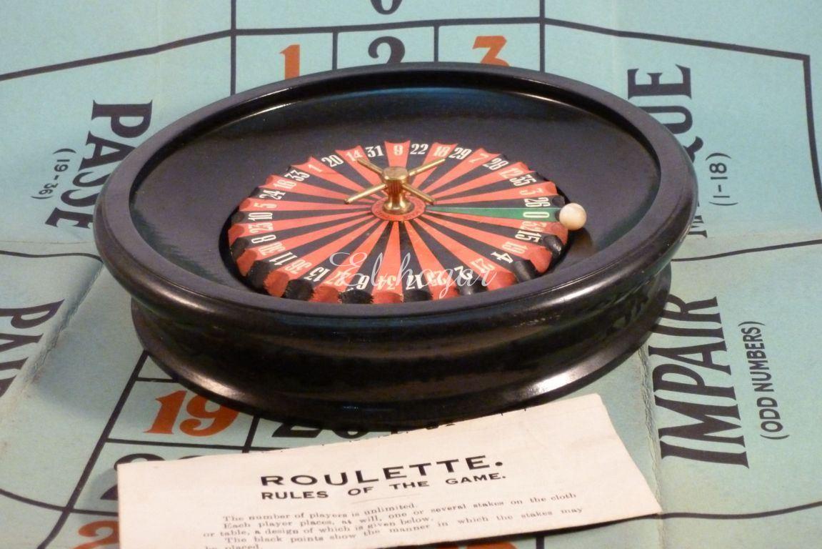 Ruleta de juguete en madera, con tapete de cartón y las reglas del juego